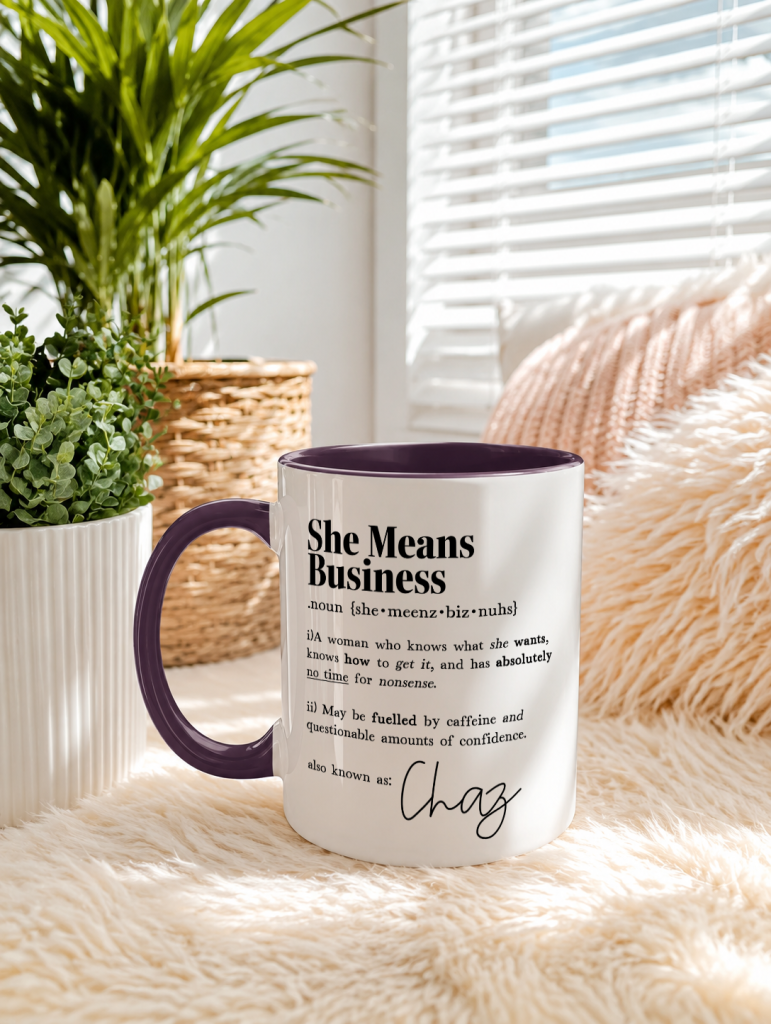 a classic white mug featuring a dark purple handle, the mug feature the phrase 'she means business' followed by a funny, light-hearted, dictionary-style definition and a personalised name.