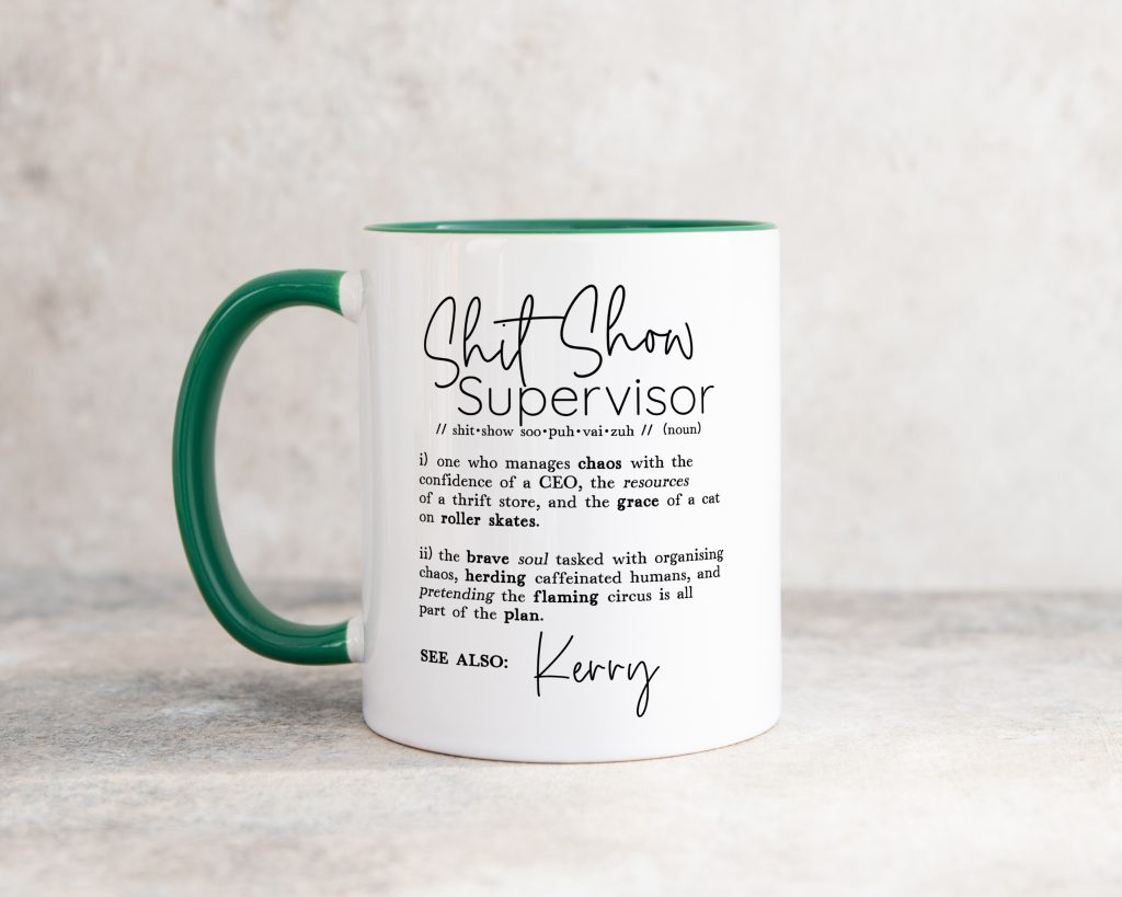 a two tone dark green ceramic mug, in white, pictured on a grey background. the mug design reads 'shitshow supervisor' followed by a light-hearted dictionary-style definition and a personalised name.
